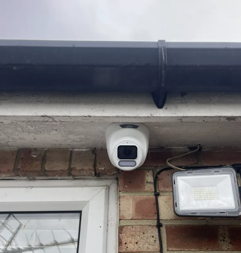 CCTV camera and floodlight above a front door